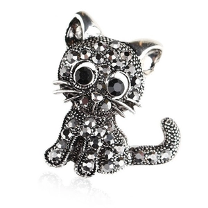 Vintage cat brooch with grey crystals and black gemstone eyes on white background