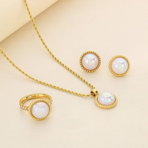 Close-up of gold twist chain necklace, shell inlay earrings and diamond ring set