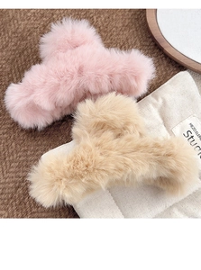 Macro detail of large plush hair claws in pink and beige faux rabbit fur texture