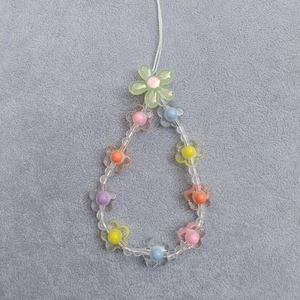 Detail of colorful acrylic flower beads and clear charms on a cute mobile phone strap