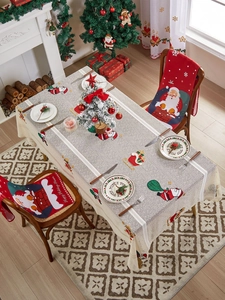 Detail of Christmas tablecloth with Santa embroidery and matching red chair covers