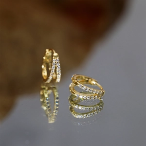 Detail of gold-plated silver double hoop earrings with pavé set white cubic zirconia stones
