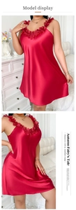 Détail d'une chemise de nuit en satin rouge avec bretelles à volants et tissu soyeux