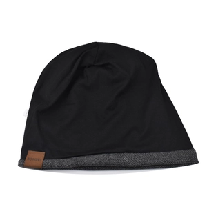 Detail of knitted beanie with grey trim and brown faux leather fashion brand label