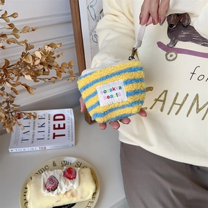 Close-up of plush striped mini pouch in yellow and blue with a soft fleece texture