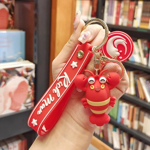Detail of red cartoon lobster keychain with Rich Man silicone strap and charms