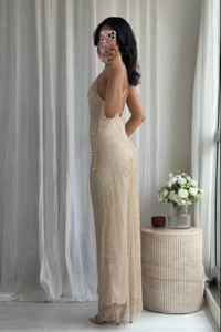 Detail of the shimmering sequins and open back design on the champagne evening dress