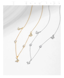 Detail of silver and gold butterfly necklaces with sparkling cubic zirconia on white background