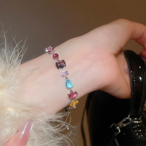 Close-up of luxury bracelet with colorful teardrop and square zircon stones on wrist