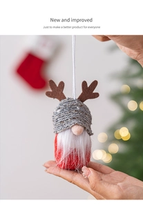 Detail of a handmade Christmas gnome ornament with reindeer antlers and a knitted hat