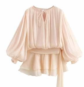 Detailed view of beige long sleeve chiffon top featuring puff sleeves and ruffled hem