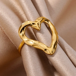 Macro detail of 18k gold plated heart ring with hammered lava texture on silk