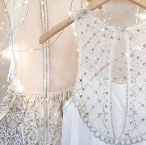 Detail of beaded sequin patterns and jacquard fabric on elegant champagne and white gowns