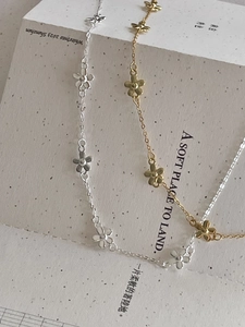 Detailed view of 925 silver and gold flower pendant necklaces on minimalist background