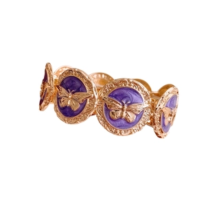 Vintage gold-toned bracelet featuring circular links with purple enamel and butterfly motifs