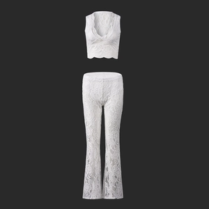 Detailed view of white floral lace texture on two-piece crop top and flared trousers set