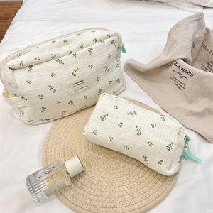 Floral quilted cotton toiletry bags set on bed showing soft texture and pattern