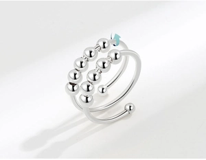 Detail view of silver adjustable anxiety ring featuring double row rotating beads and spin motion