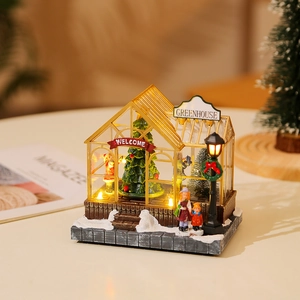 Detail of a glowing Christmas miniature greenhouse with warm LED lights and festive decor