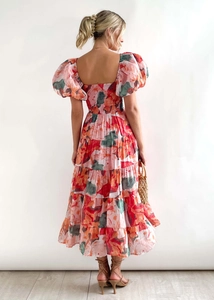Rear view of floral tiered maxi dress featuring puff sleeves and smocked back panel