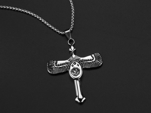 Macro detail of silver eagle cross pendant with intricate metal engravings on box chain