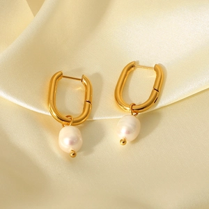Detail shot of golden oval hoop earrings with freshwater pearls on silk fabric
