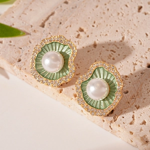 Détail macro d'une boucle d'oreille vintage avec émail vert, perle et cristaux sur pierre