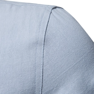 Macro detail of high-quality double-stitching on light blue cotton shirt shoulder