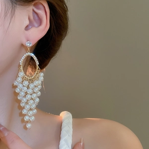 Detail of long tassel earrings featuring pearl grape cluster and sparkling zircon accents
