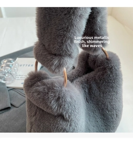 Close-up of a plush grey faux fur handbag featuring elegant light gold metal ring handles