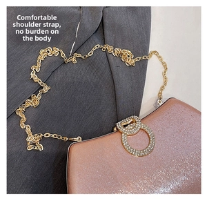 Detail of rose gold evening clutch featuring a sparkling finish and rhinestone ring buckle