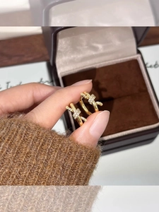 Gros plan de boucles d'oreilles nœud plaquées or avec zircons sur un coffret de luxe