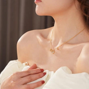 Dettaglio di una collana con ciondolo a quadrifoglio bianco placcato oro 18 carati