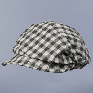 Detailed view of green and white plaid linen newsboy cap with soft textured fabric