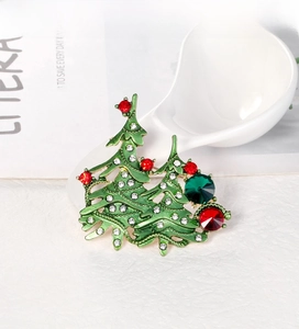 Close-up of a festive Christmas tree brooch with green enamel and sparkling rhinestones