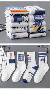 Detail of white cotton athletic socks featuring contrast stripes and rib knit cuffs