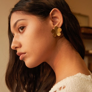Elegant 18k gold plated stainless steel daisy flower stud earrings worn by a model