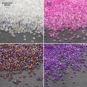 Macro detail of 2mm rainbow glass seed beads in white, pink, multicolor and purple