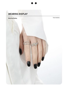 Wearing display of irregular silver wavy rings with green zircons on a white background