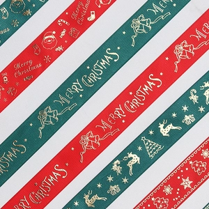 Close-up of red and green ribbed Christmas ribbons with gold foil Merry Christmas prints