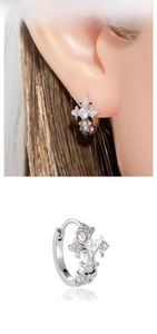 Macro shot of silver cross hoop earrings with inlaid zircons and vintage lace edge detail