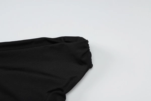 Detail of black slim-fit T-shirt showing high-quality fabric texture and ruched design