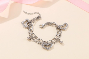Détail du bracelet multicouche en acier inoxydable avec pendentifs cœurs et perles