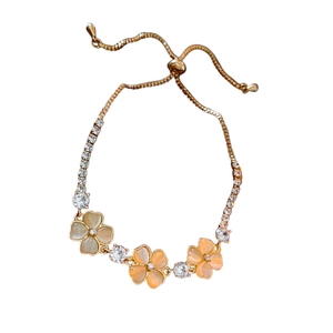 Adjustable gold flower bracelet with cat eye stones and sparkling cubic zirconia charms