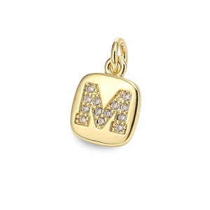 Close-up of a square gold pendant featuring letter M and sparkling zircon stones