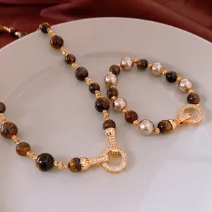 Tiger eye and pearl necklace set with gold plating on red silk backdrop