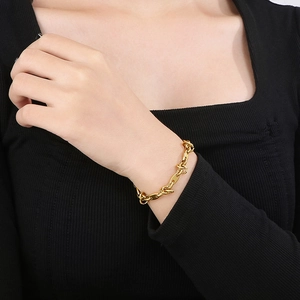 Detail of a knot design gold titanium steel chain necklace worn on a model's neck