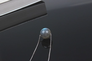 Macro shot of natural labradorite pendant with blue sheen on a silver chain