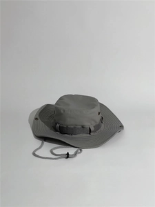 Close-up of a dark grey outdoor sun hat with adjustable chin strap and metal air vents