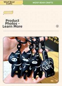 Detail of four black leather cat keychains with white embroidery and golden flower accents